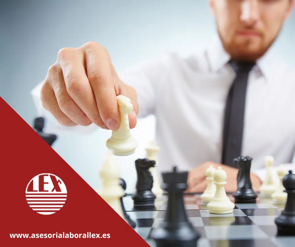 Profesional desarrollando estrategia de pacto no competencia jugando ajedrez en oficina. Utilizada como fondo en un blog de Asesoría Lex