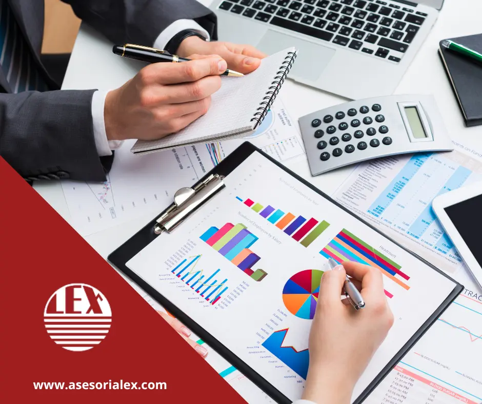 Profesional analizando gráficos para externalizar la contabilidad con calculadora y laptop. Utilizada como fondo en un blog de Asesoría Lex